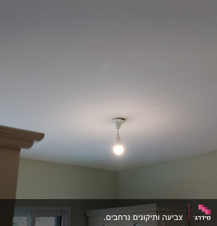 נורה תלויה מהתקרה בחדר מואר